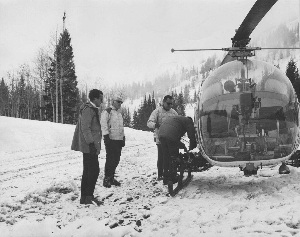 Dan Kiley and Jack Smith by a helicopter at Snowbird Resort.